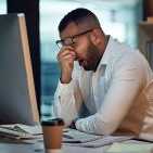 Shot of a young businessman experiencing stress during late night at work