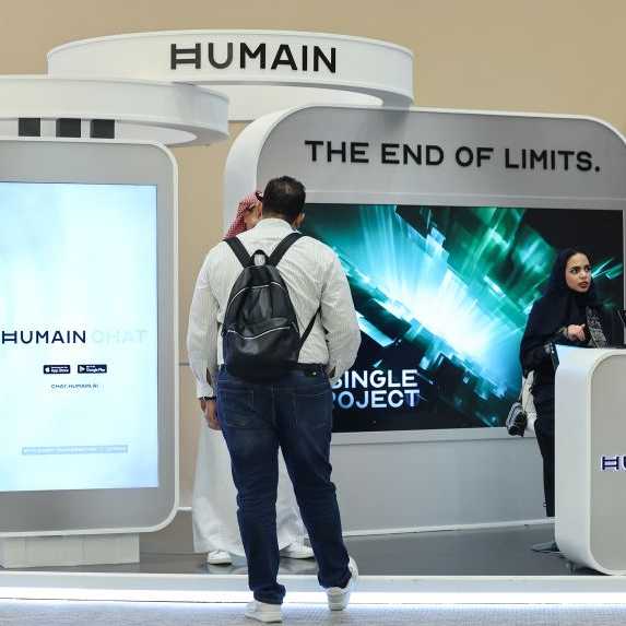Guests stand at the booth of Saudi artificial intelligence company Humain.
