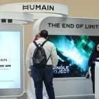 Guests stand at the booth of Saudi artificial intelligence company Humain.