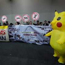 Activists, and one dressed in a Pikachu costume, protest Japan's financing of coal and natural gas projects during the COP30
